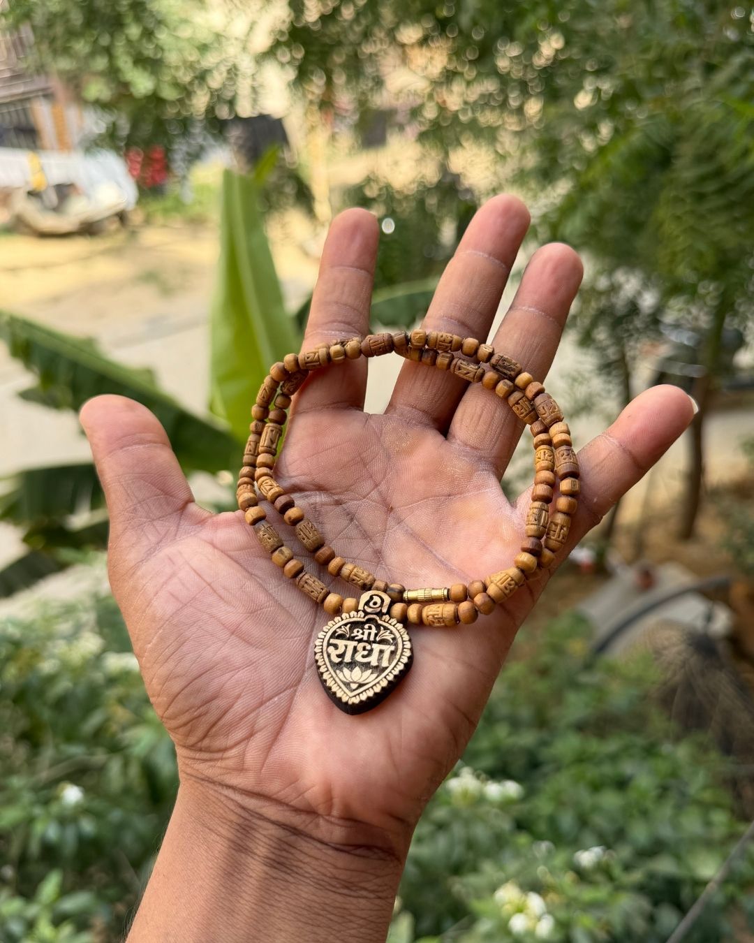 Close up of Shri Radha Locket and Radha Name Brown Tulsi Mala with round Tulsi beads
